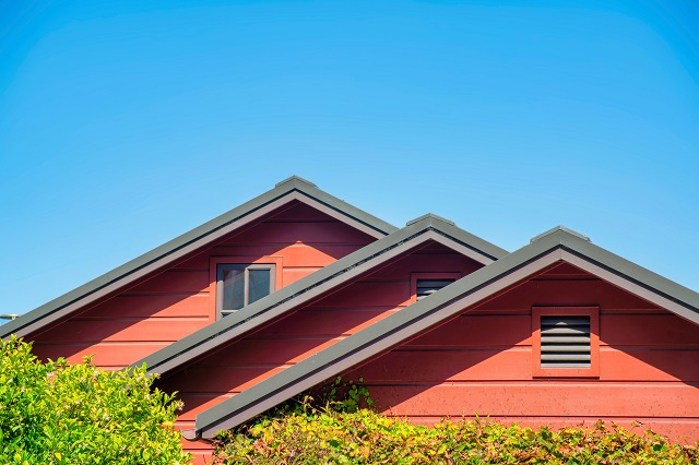 Top of a home with staggered roof peaks and gable vents