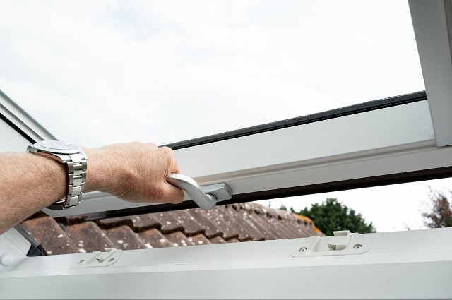 Person manually closing a skylight