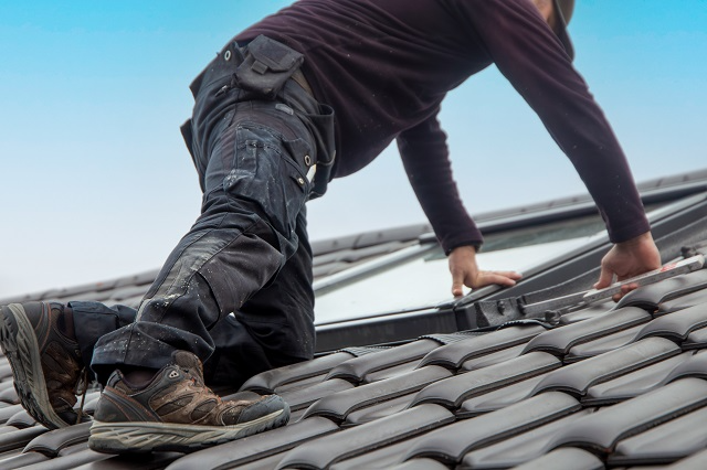 Roofing contractor installing a skylight on a roof