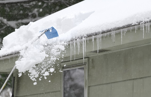 Roof rake raking snow off of a roof