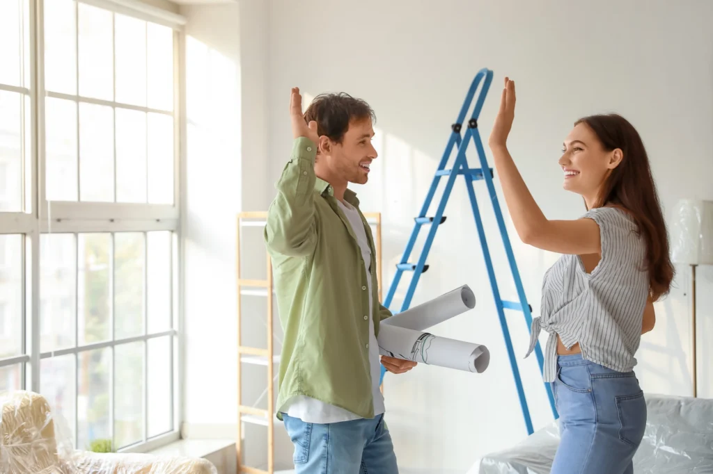 Couple hi-fiving while working on a home improvement project