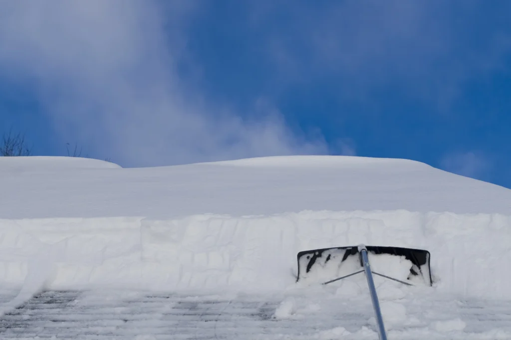 Roof rake pulling snow off of a roof