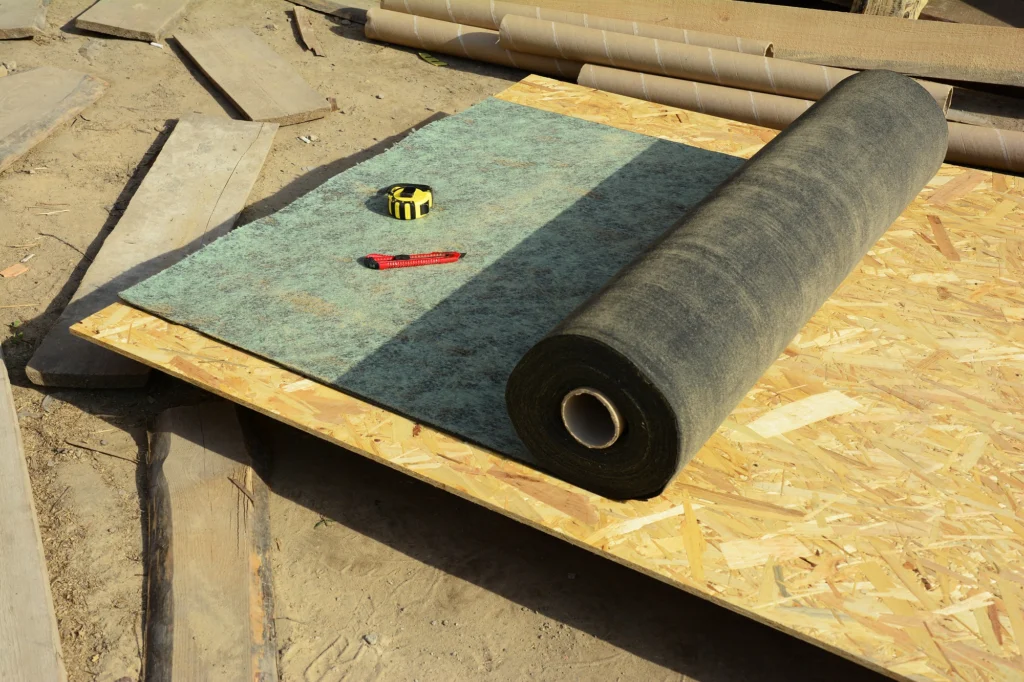 Closeup of a roll of roof underlayment and roof decking